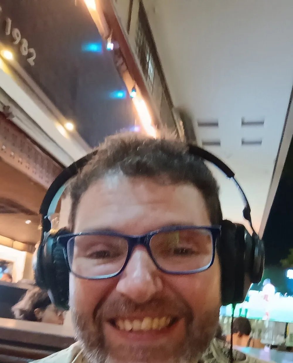 Gui Loureiro de fone de ouvido, sorrindo, numa call