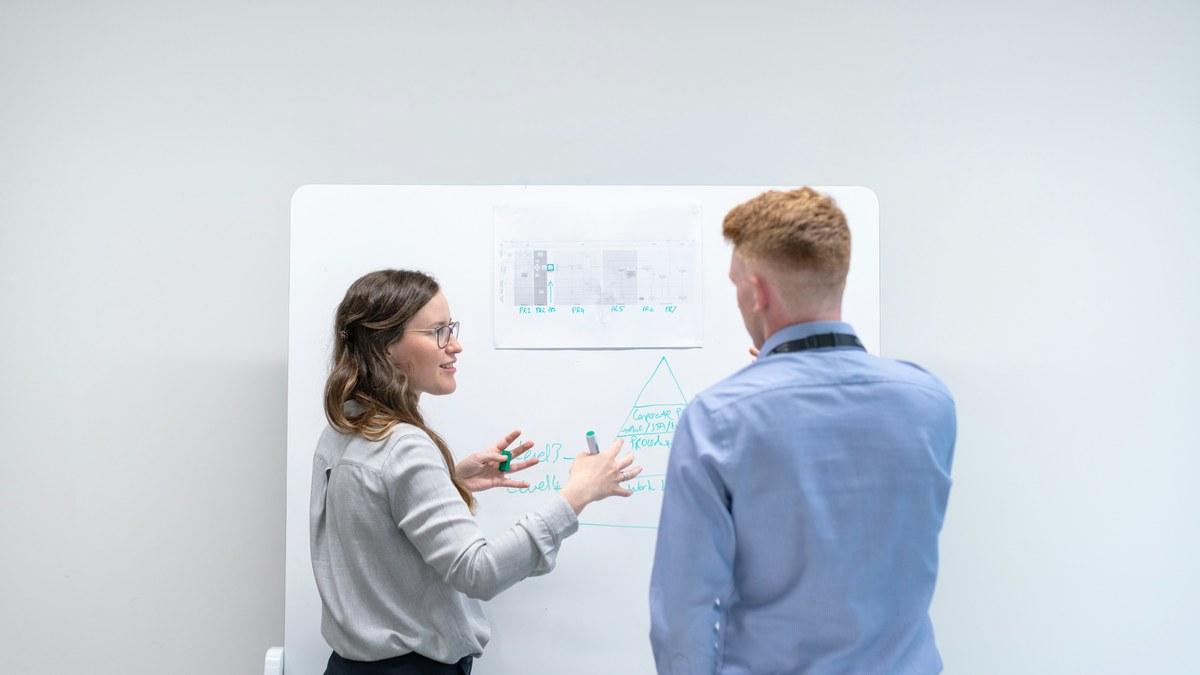 Reunião de time de growth analisando modelo de atribuição projetado em tela