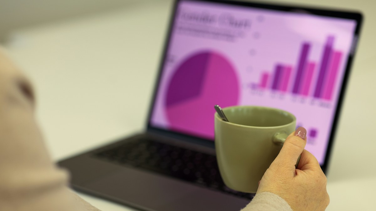 Mãos de profissional ajustando modelo de atribuição em laptop com dashboard de conversão