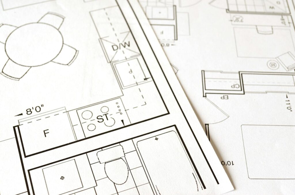 Planta arquitetural detalhada com régua e lápis · metáfora visual pra sistema de marketing como infraestrutura projetada