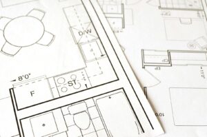 Planta arquitetural detalhada com régua e lápis · metáfora visual pra sistema de marketing como infraestrutura projetada