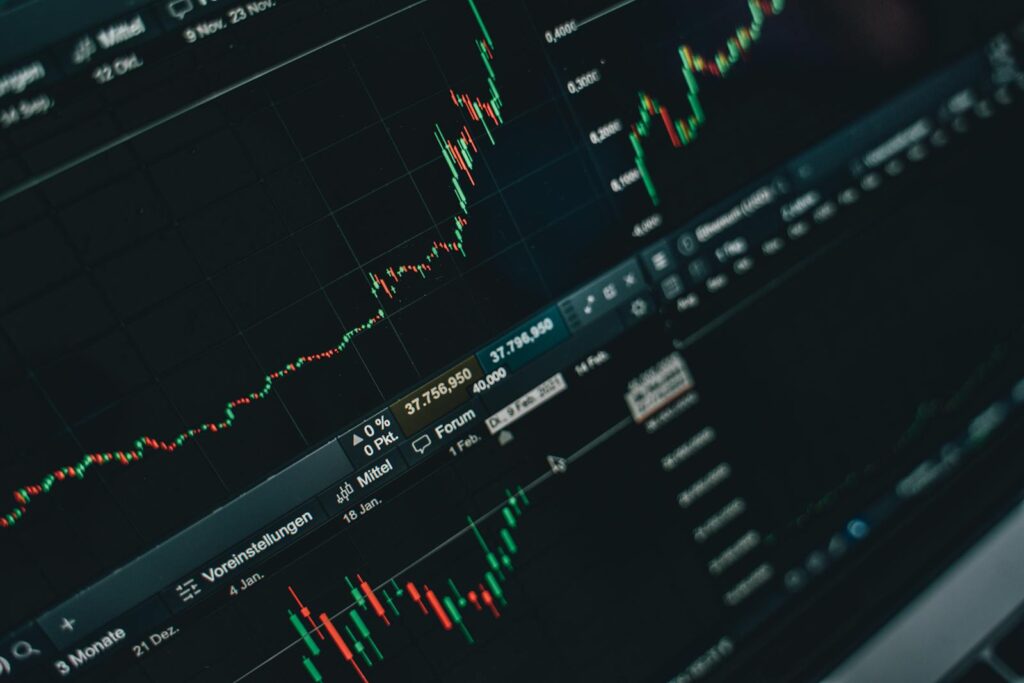 Close-up de gráficos de mercado financeiro em tela de laptop · first-party data e atribuição em 2026