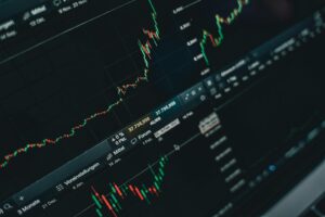 Close-up de gráficos de mercado financeiro em tela de laptop · first-party data e atribuição em 2026