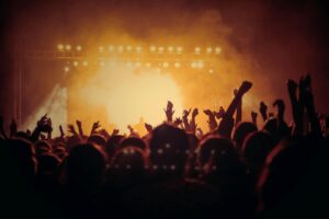 Multidão em concerto sob luzes de palco · ativação real muda comportamento, não só aparência de evento